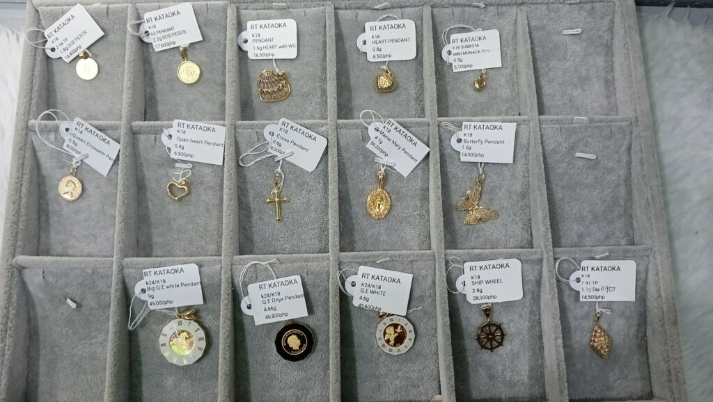Large collection of 18k and 24k gold pendants including Mama Mary, Queen Elizabeth coins, and butterflies.